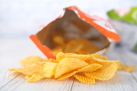 tasty potato chips on wooden background