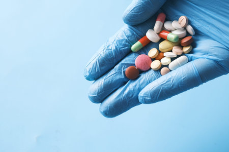 many medical pills on palm of hand with copy space .
