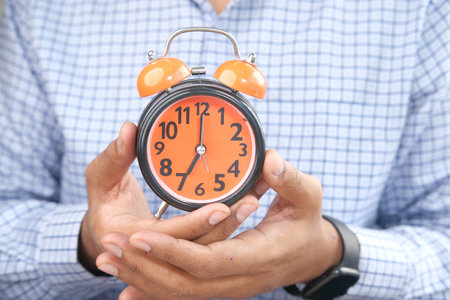 man hand holding alarm clock close up ,の写真素材