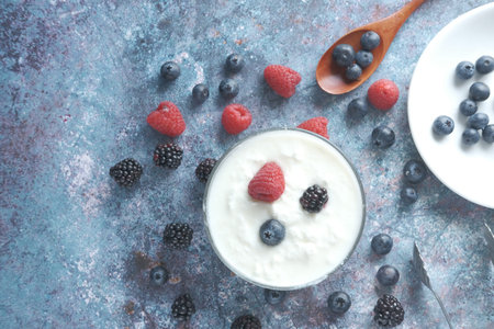 close up of fresh yogurt with blue berry in a bowl .