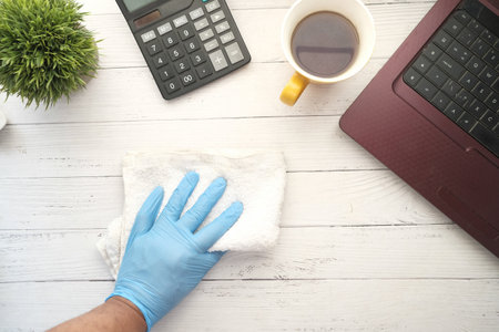 Person hand in disposable gloves clean table surface.の写真素材