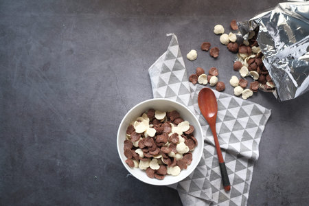 Top view of chocolate corn flakes in a bowl on pink .