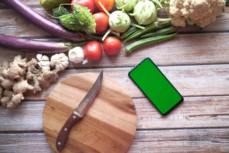 fresh vegetables, cutting board and smart phone on table ,の写真素材