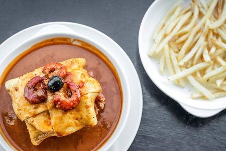 famous francesinha traditional meat cheese and spicy sauce grilled sandwich of porto portugalの写真素材