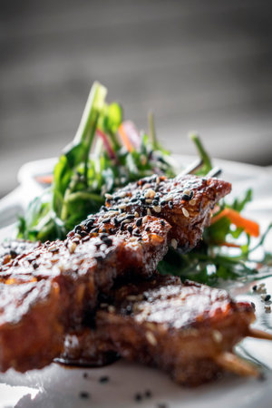 asian spicy sweet soy sauce and sesame seed grilled barbecue pork skewers in singapore restaurantの写真素材