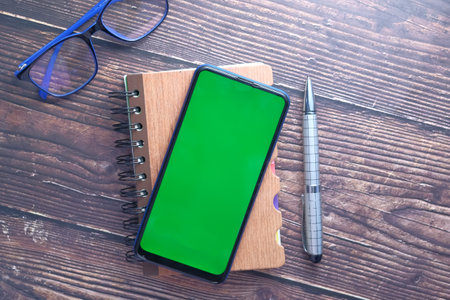 top view of smart phone and notepad on table .の写真素材