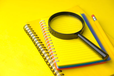 open book and magnifying glass on table