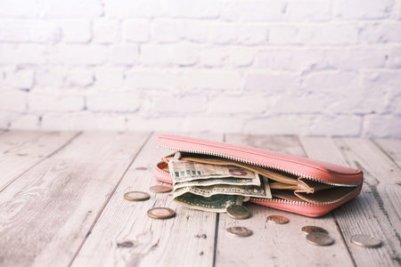 us dollar cash and coins in leather wallet on table ,