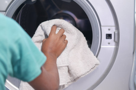 putting towel and cloths in a washing machineの写真素材