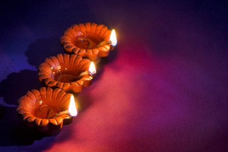 Clay diya lamps lit during Diwali Celebration. Greetings Card Design Indian Hindu Light Festival called Diwaliの写真素材