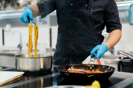 front view chef with gloves cooking pasta kitchenの写真素材