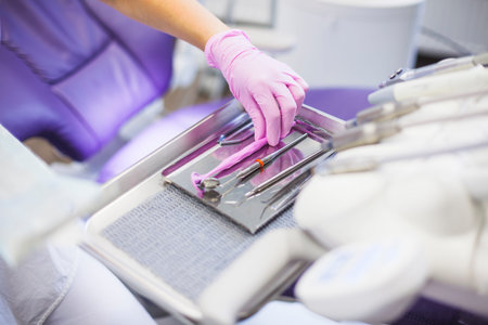 close up dentist s hand arranging dental tools tray