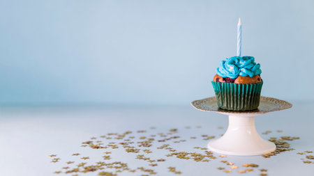 candle cupcake cakestand against blue backgroundの写真素材