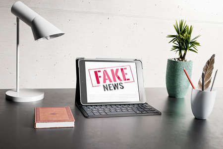 desk with laptop fake newsの写真素材