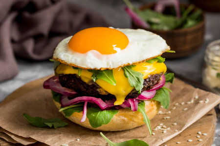 high angle cheeseburger with fried egg cutting board