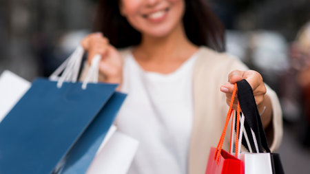 defocused smiley woman holding shopping bags after sale sessionの写真素材