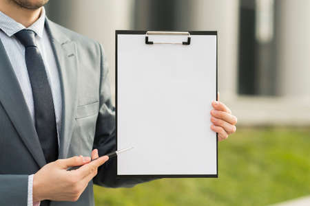 businessman presenting clipboardの写真素材