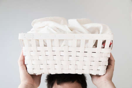 front view person holding laundry basket headの写真素材