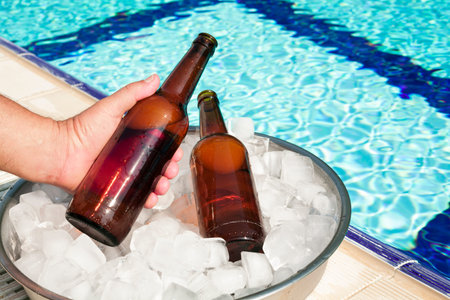 hand taking out beer bottle out tray with ice
