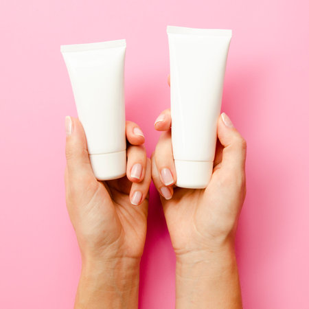 close up hands holding cream bottlesの写真素材