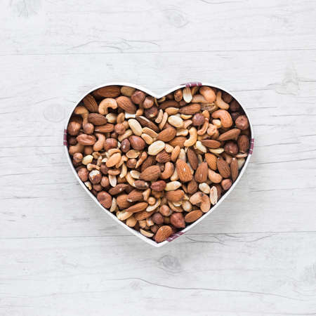 top view healthy dryfruits heart shape wooden deskの写真素材