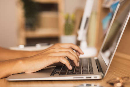 hands typing laptop lateral viewの写真素材