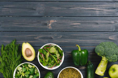 green fresh vegetables black wooden deskの写真素材