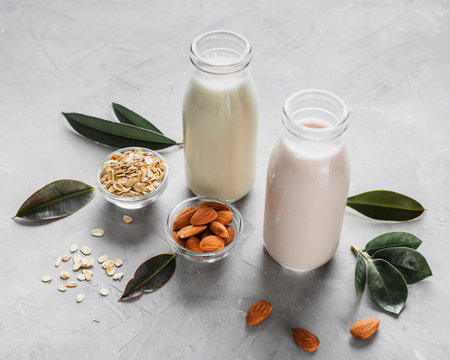 high angle milk bottles with almonds oats