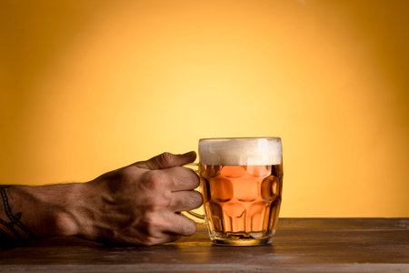 man holding glass beer wooden table