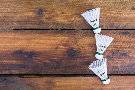 three shuttlecocks wooden textured backgroundの写真素材