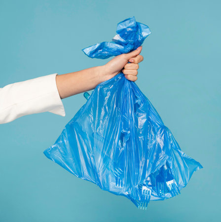 woman holding blue plastic trash bag