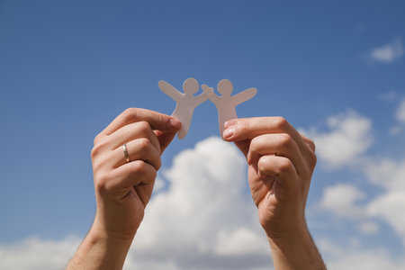 paper dolls against sky . Resolution and high quality beautiful photoの写真素材
