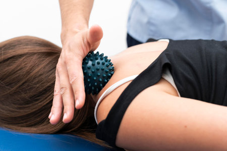woman getting massage from physiotherapist with ball neckの写真素材