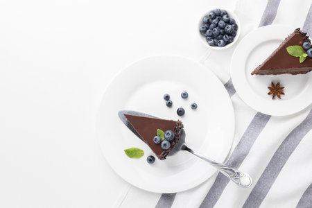 top view chocolate cake slices plates with blueberriesの写真素材