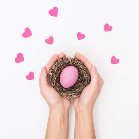 person holding nest with bright easter eggの写真素材
