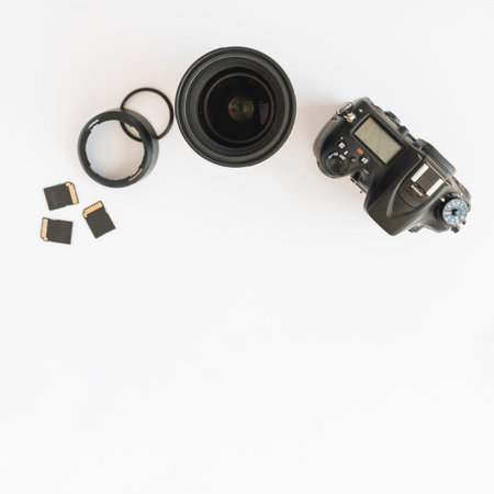 top view dslr camera memory cards camera lens with extension rings white backdrop