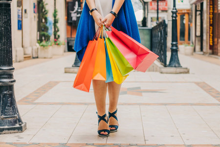 unrecognizable woman with shopping bagsの写真素材