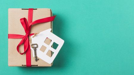 brown gift box tied with red ribbon house key turquoise surface. Resolution and high quality beautiful photoの写真素材