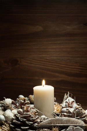 white candle lit with pine cone ornaments. Resolution and high quality beautiful photoの写真素材