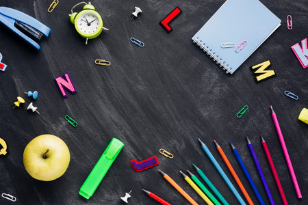 school stationery with apple alarm clock scattered blackboard