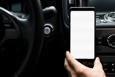 close up hand holding smart phone showing white blank screen car