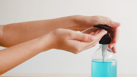 Asian woman using alcohol gel hand sanitizer wash hand for protect coronavirus. Female push alcohol...