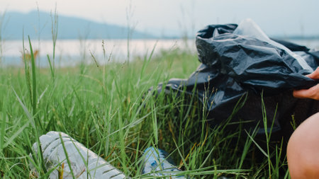 Happy young Asia activists collecting plastic waste on the forest. Korean lady volunteers help to keep nature clean up and pick up garbage. Concept about environmental conservation pollution problems.の写真素材