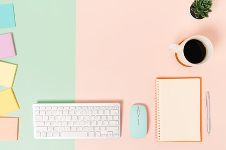 Creative flat lay photo of workspace desk. Top view office desk with keyboard, mouse and open mockup black notebook on pastel green pink color background. Top view mock up with copy space photography.の写真素材