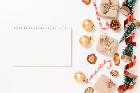 Minimal creative flat lay of winter christmas traditional composition and new year holiday season. Top view open mockup black notebook for text on white background. Mock up and copy space photography.の写真素材