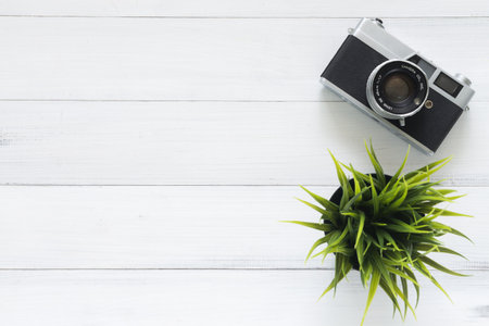 Minimal work space - Creative flat lay photo of workspace desk. Office desk wooden table with old camera. Top view with copy space. Top view of old camera over wooden table. Retro vintage filter.の写真素材