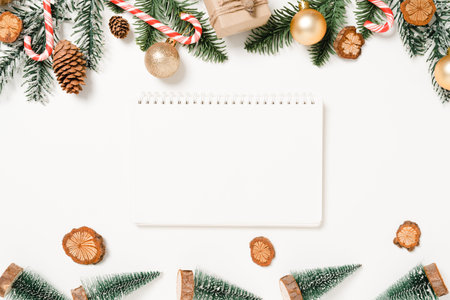 Minimal creative flat lay of winter christmas traditional composition and new year holiday season. Top view open mockup black notebook for text on white background. Mock up and copy space photography.の写真素材