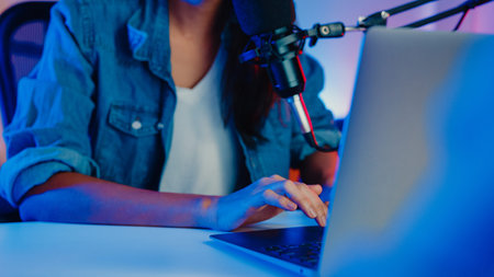 Happy asia girl host record podcast use microphone wear headphone with laptop interview guest...