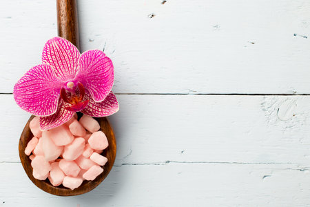 Sea salt wooden spoon on the pink orchid.の写真素材
