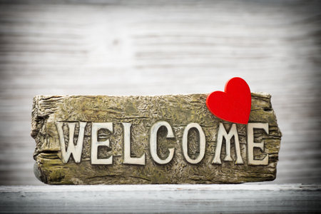 On the wood background of a plaque with an inscription welcome.の写真素材